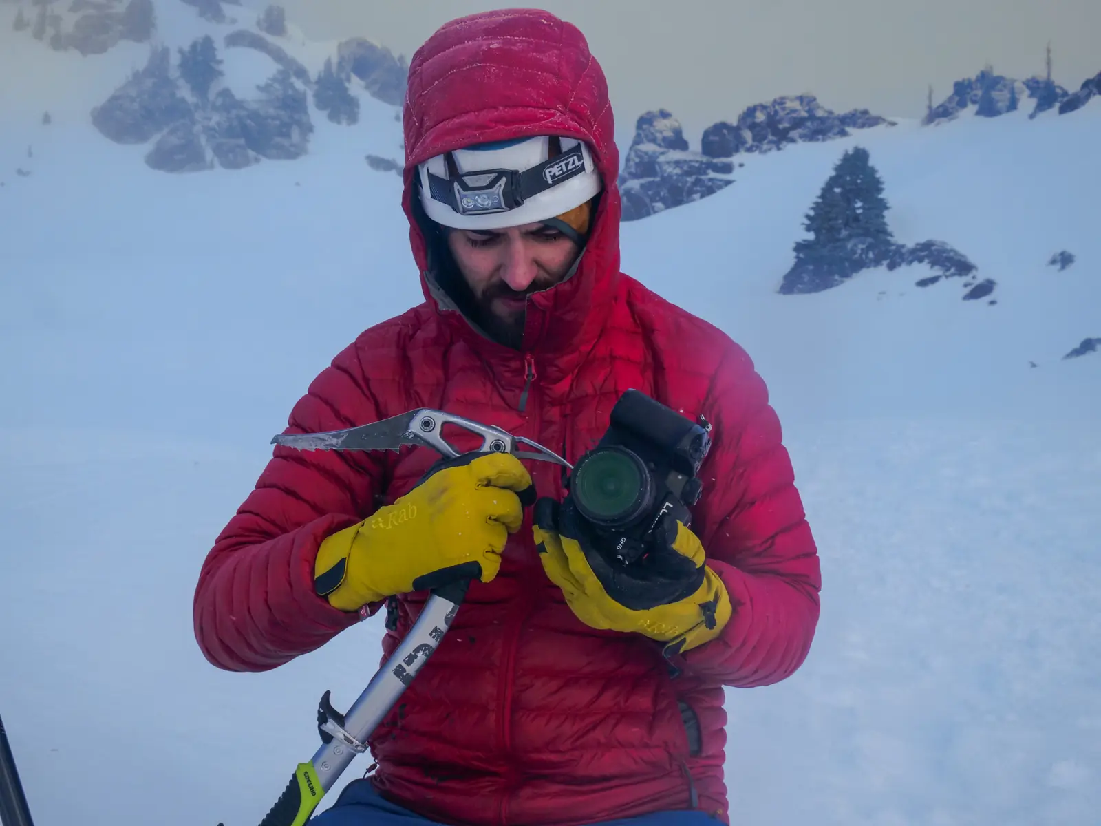 Ultra Nomadic Media photographer holding a camera and ice axe on a snowy mountain during an outdoor product shoot